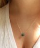Raw Emerald stone necklace on model 